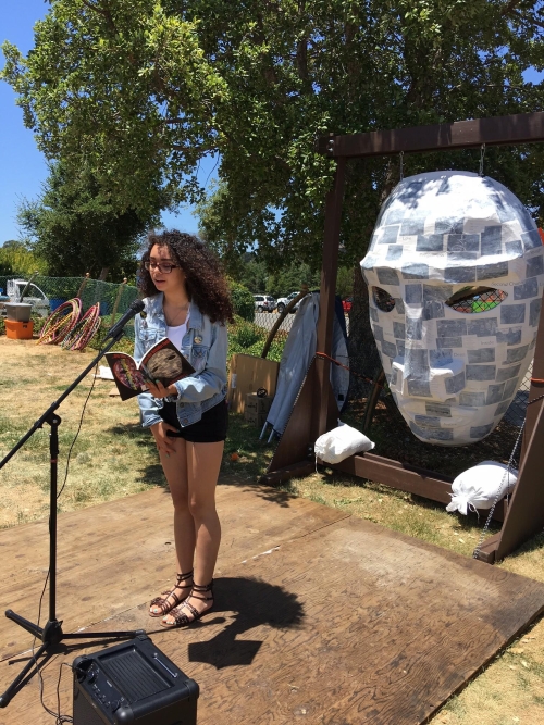 Reading in front of Poetry Mask created by Alejandro Lopez and ForWords Literacy Lab students